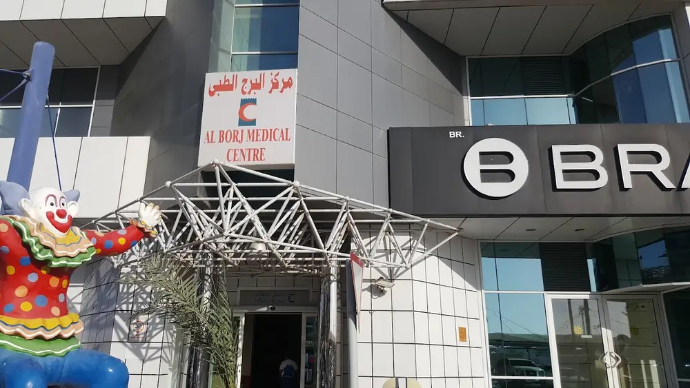 Glass entrance of Al Borj Medical Center with its name in English and Arabic