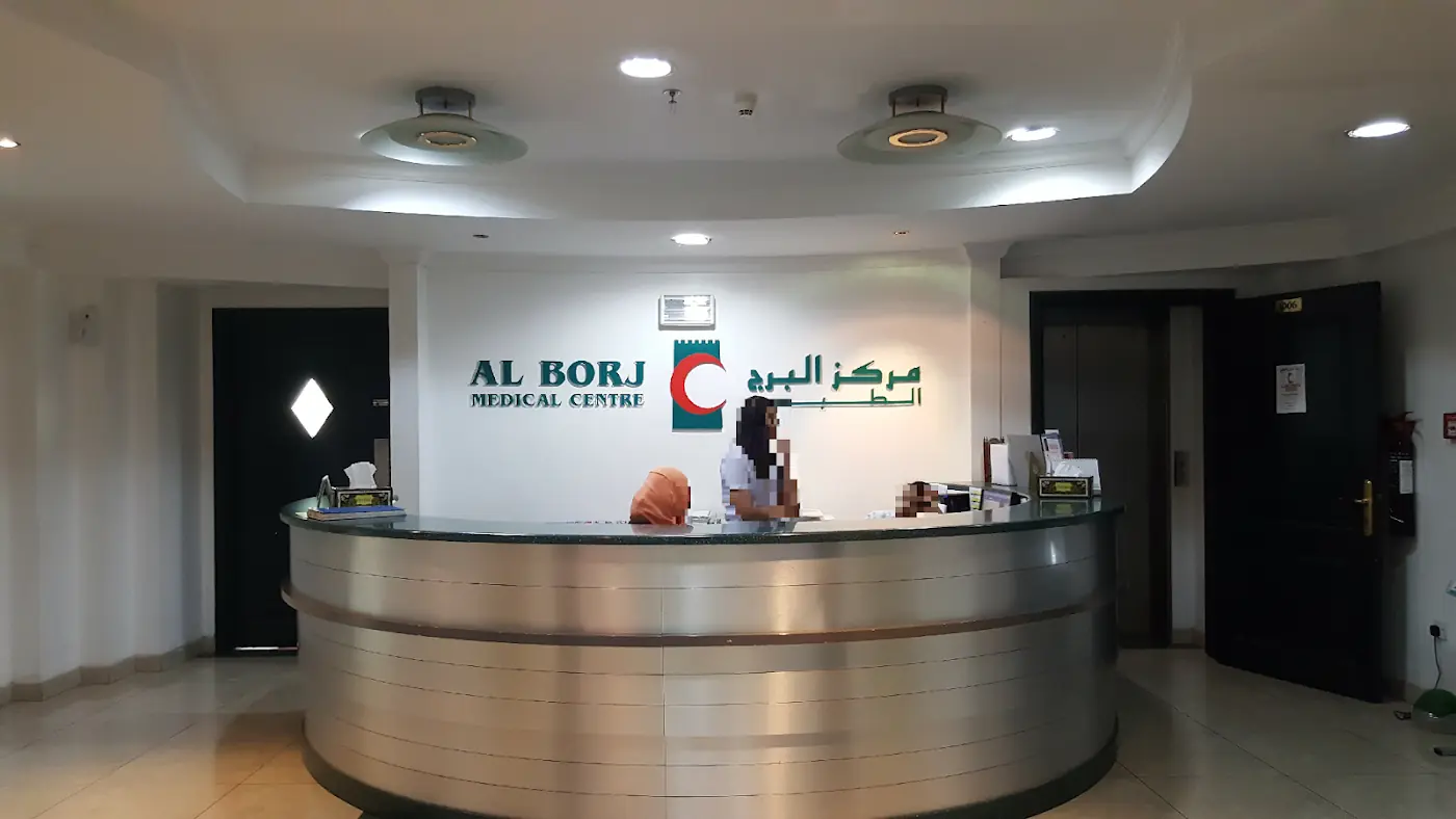 Reception desk at Al Borj Medical Center with the clinic’s logo on the wall